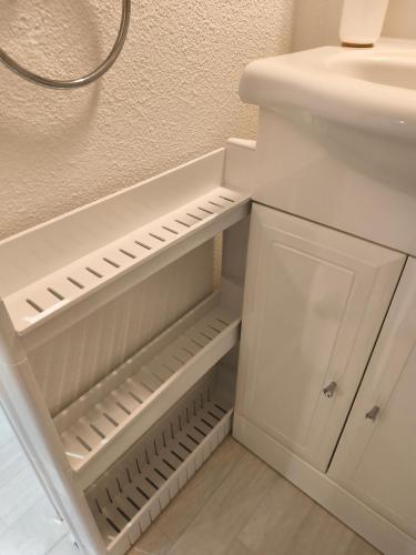 a bathroom with a sink and a white cabinet at Notre location au Barcarès in Le Barcarès