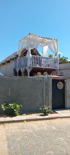 a house with a balcony on top of a wall at Erina Beach in Antalaha