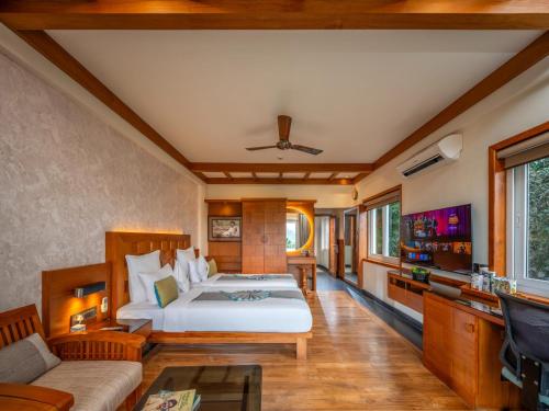 a bedroom with a bed and a flat screen tv at Chandys Windy Woods Munnar in Munnar