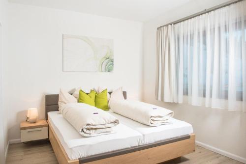 a bedroom with a bed with white and green pillows at Villa Valentine in Flachau