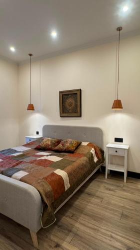 a bedroom with a bed and two tables and two lamps at Burada in Baku