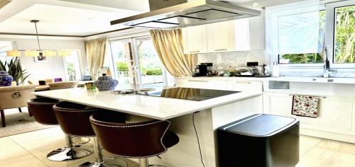 a kitchen with a island with bar stools at Maisonn La Turbie - Privateee pool in La Turbie