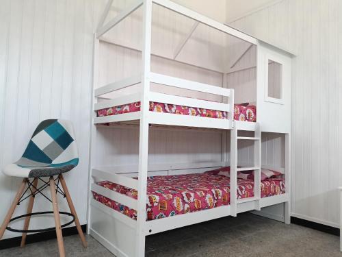 a bedroom with a white bunk bed and a chair at Domos Ventuno Barumini in Barùmini