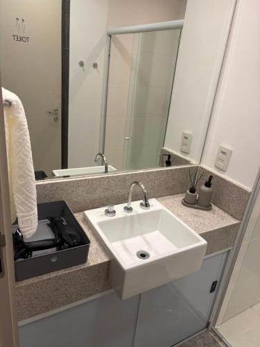 a bathroom with a white sink and a mirror at Flat 503 - America in Campos dos Goytacazes