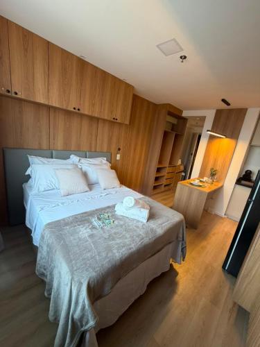 a bedroom with a large bed with wooden walls at Flat 503 - America in Campos dos Goytacazes