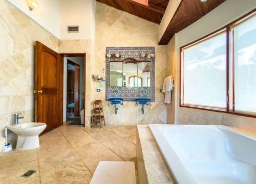a bathroom with a tub and a toilet and a mirror at Casa Las Palmas in San Andrés