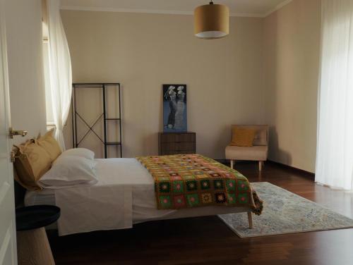 a bedroom with a bed and a chair at Domus Flumen in Alife
