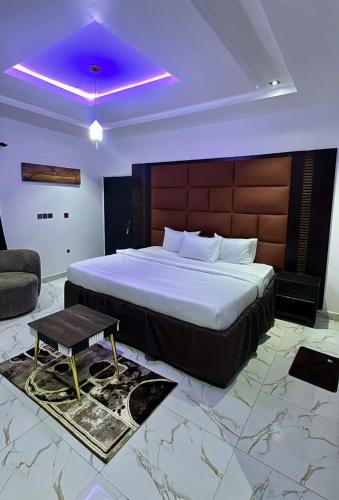 a bedroom with a large bed and a purple ceiling at Eraton Hotel in Warri