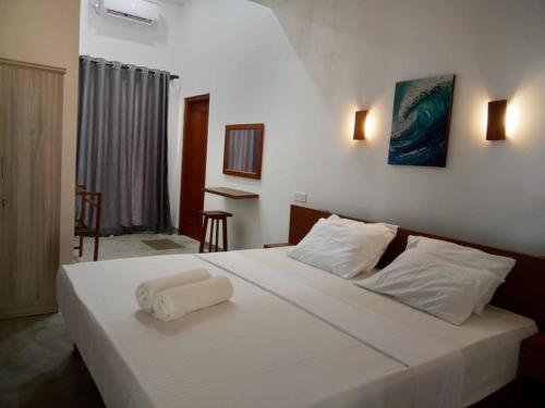 a bedroom with a white bed with two towels on it at Yara Eleven in Ambalangoda