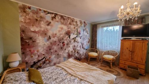 a bedroom with a flower mural on the wall at Agroturystyka u Bogusi in Sarbinowo