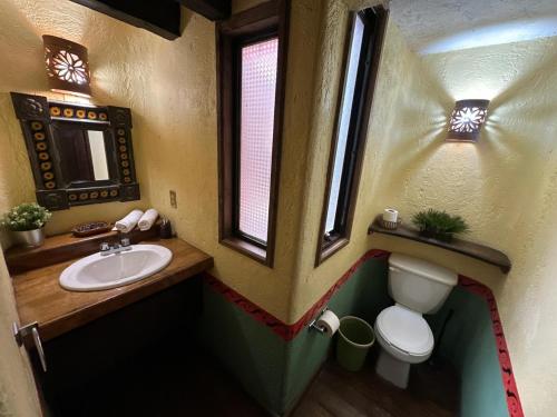 a bathroom with a sink and a toilet and a window at Rancho Cumbre Monarca in La Ciénega