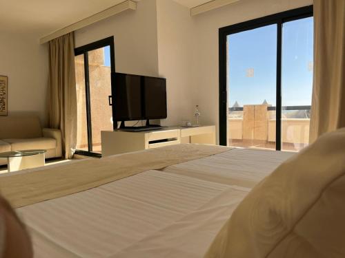 a bedroom with a large bed and a television at AR Almerimar in Almerimar