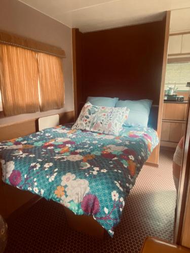 a bedroom with a bed with a quilt on it at Venez Dormir chez Nous Dans Les BaRoNNieS ! Dans notre Caravane CARavelaiR 1979 in Labastide