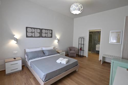 a white bedroom with a bed and a chair at Villa Grazia in Oliveto Citra