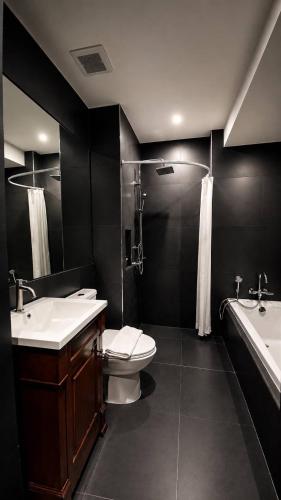 a bathroom with a toilet and a sink and a tub at Srianunt Boutique Hotel in Buriram