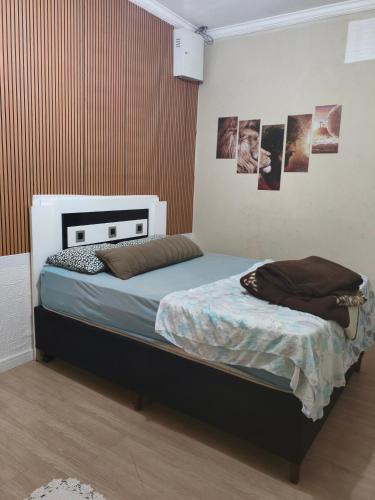 a bedroom with a bed with pictures on the wall at Hostel Durães 01 in Londrina