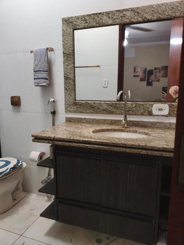 a bathroom with a sink and a mirror at Hostel Durães 01 in Londrina