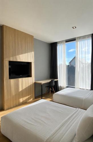 a hotel room with two beds and a desk at Srianunt Boutique Hotel in Buriram