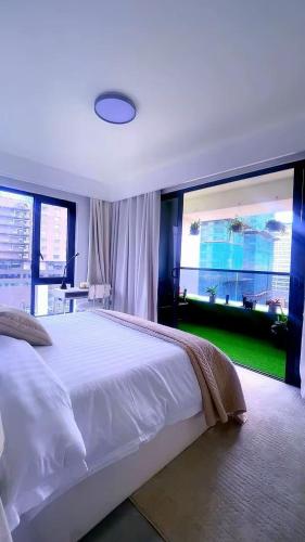a bedroom with a large white bed and a large window at SS Kileleshwa Homes in Nairobi