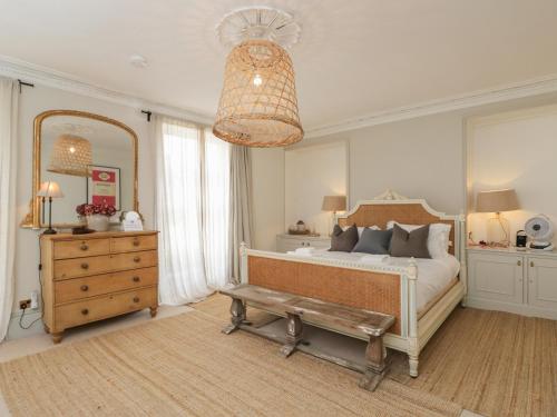 a bedroom with a bed and a dresser and a mirror at Cotswold House in Moreton in Marsh