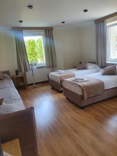 a bedroom with three beds in a room at Pokoje gościnne vis a vis Retro in Gostynin