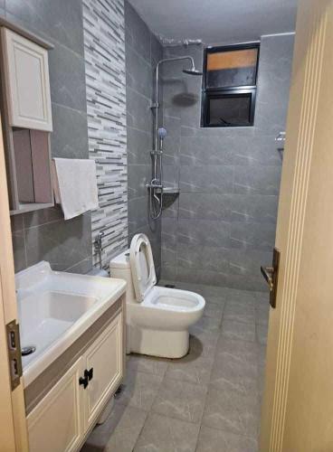 a bathroom with a toilet and a sink at SS Kileleshwa Homes in Nairobi