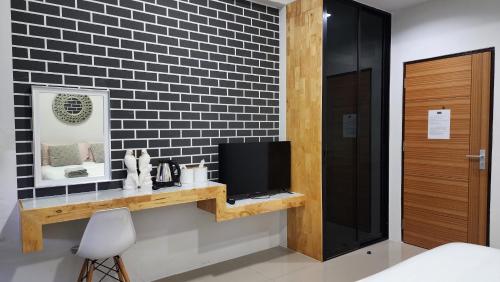 a room with a tv on a shelf and a wall at Irich residence South Samrong 6 Kms BTS-Pu Chao in Samut Prakan