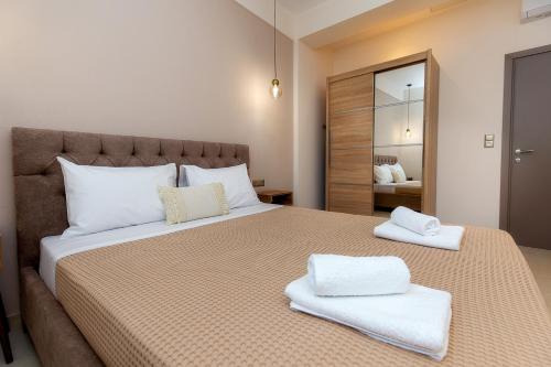 a bedroom with a large bed with two towels on it at Zen Garden Villa in Theológos