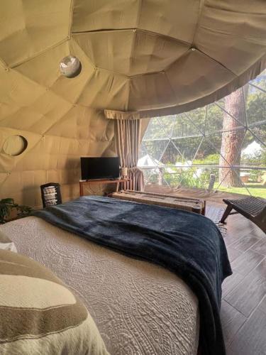 ein Schlafzimmer mit einem großen Bett in einem Zelt in der Unterkunft Lunada Mazamitla in Mazamitla