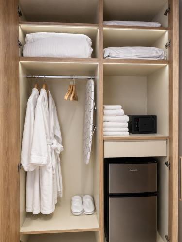a closet with white towels and a bed at Ventora Suites in Nydri