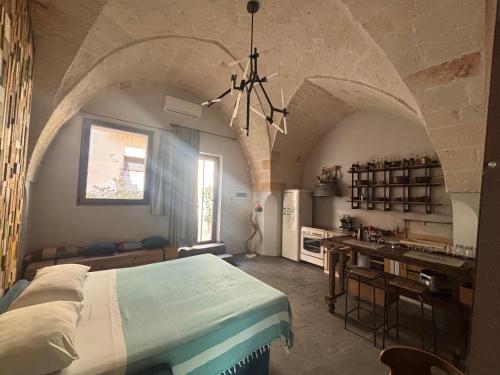 a bedroom with a bed and a kitchen in a room at SUITES JACUZZI La Stratodda OSTUNI Torre Guaceto in San Vito dei Normanni