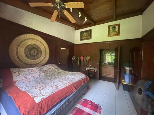 a bedroom with a bed and a ceiling fan at Fare Taitua in Papara