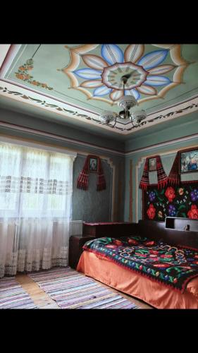 a bedroom with a flower painted on the ceiling at La Umbra Muntilor Traditional House in Ocoliş
