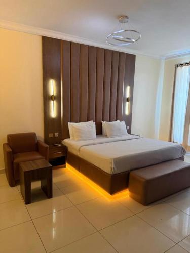 a hotel room with a bed and a chair at POSH HOTEL iSLAND in Victoria Island