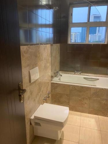 a bathroom with a toilet and a bath tub at POSH HOTEL iSLAND in Victoria Island
