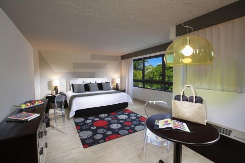 a hotel room with a bed and a table and chairs at Oh! Cancun - The Urban Oasis & beach Club in Cancún