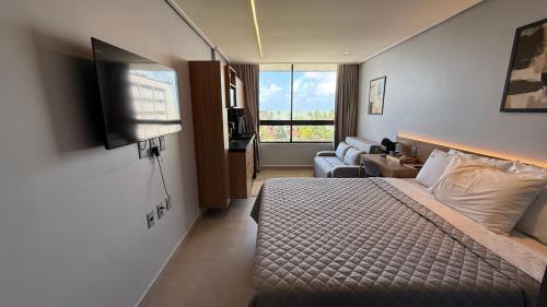a hotel room with a bed and a television at Acqua Tambaú Luxury Flat 100 meters from the sea in João Pessoa