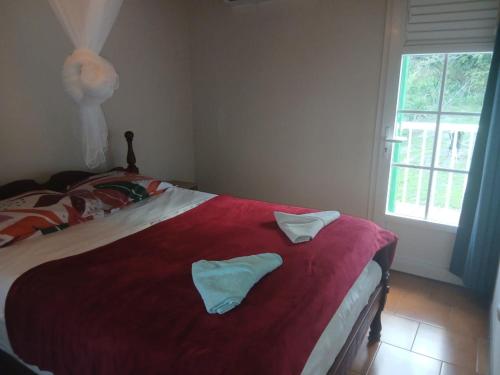a bedroom with a bed with two towels on it at Villa creole in Le Diamant