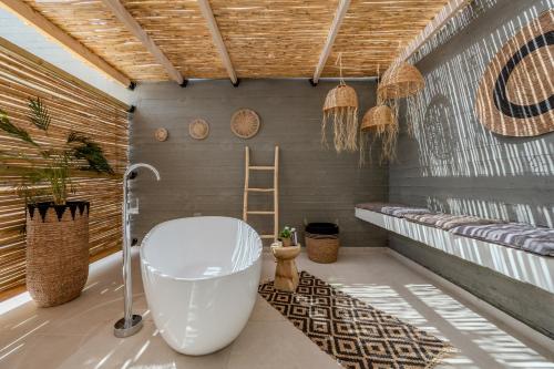 a bathroom with a white tub and a wooden ceiling at Evgoro Luxury Suites in Agia Galini