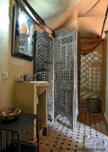 a bathroom with a shower with a sink and a mirror at Sahara Sunset Luxury Camp M'hamid in Mhamid