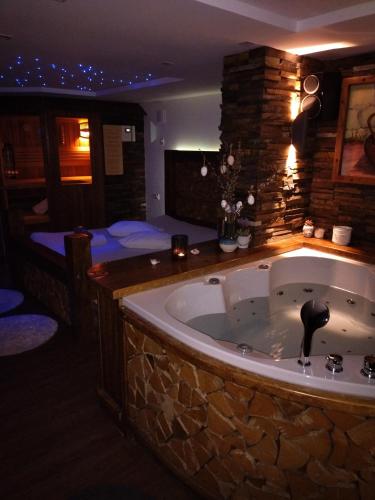 a large bath tub in a room with a bedroom at Haloze ForMe in Zavrč
