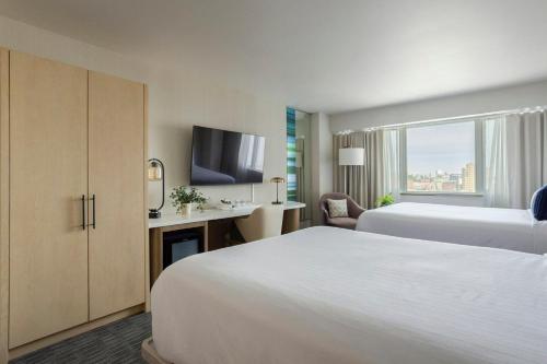 a hotel room with two beds and a television at Hotel Murano in Tacoma