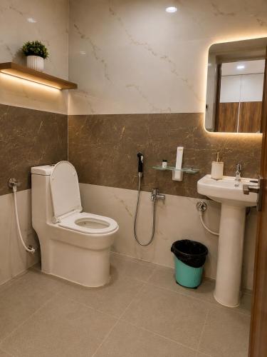 a bathroom with a toilet and a sink at Hotel jetway in Muthugadahalli