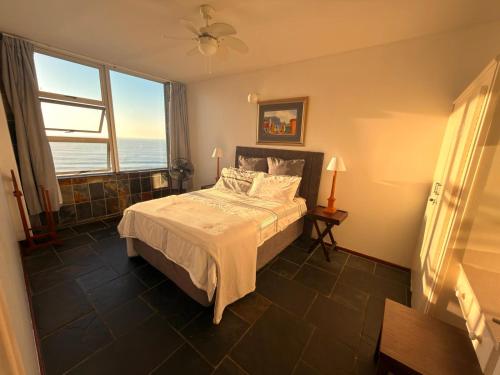 ein Schlafzimmer mit einem Bett und einem großen Fenster in der Unterkunft Ocean rest in Scottburgh