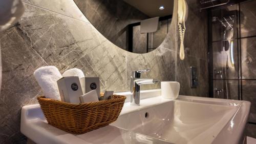a bathroom with a sink and a basket of towels at Pasaport Pier Hotel in İzmir