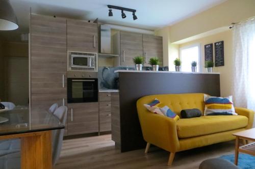 a living room with a yellow couch in a kitchen at Viv. Turística Museo del Comercio in Salamanca