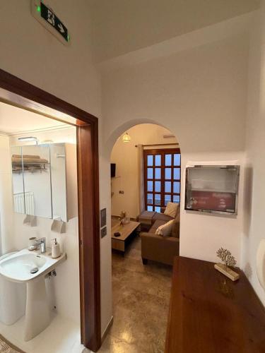 a bathroom with a sink and a living room at Petalidi seaside Retreat in Petalidi