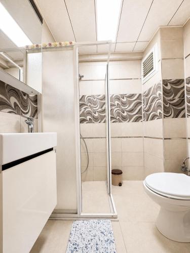 a bathroom with a shower and a toilet at Askin Suits Canakkale in Çanakkale