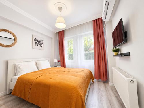 a bedroom with a bed with an orange blanket at Askin Suits Canakkale in Çanakkale