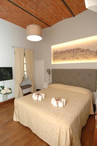 a bedroom with a large bed with two towels on it at B&B La Loggia e L’Orologio in Castiglione del Lago